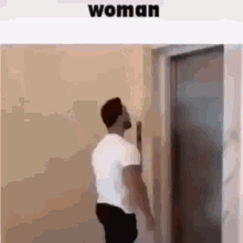 a man is standing in front of an elevator and looking up .