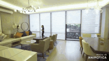 a woman stands in a living room with the words made in animotica on the bottom right