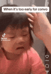 a little girl is crying while a woman holds her hair .