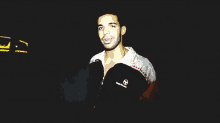a man in a red white and black sweater is standing in the dark