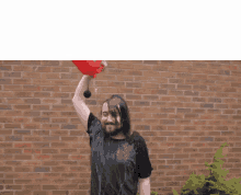 a man is pouring water from a red can