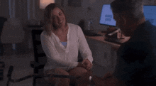 a woman is sitting in a wheelchair holding hands with a man .