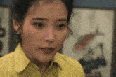 a close up of a woman 's face in front of a painting