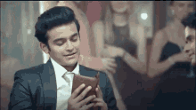 a man in a suit is holding a wallet in his hands