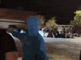 a person wearing a blue hoodie is standing in front of a building