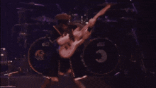 a woman in a maid costume is playing a guitar on stage