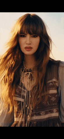 a woman with long hair and fringe is wearing a dress