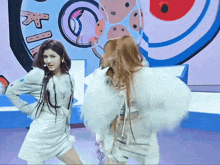 two women are dancing in front of a sign that says " ki "