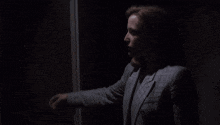 a woman standing in a dark room with the words " the fbi 's most unwanted " written on the bottom