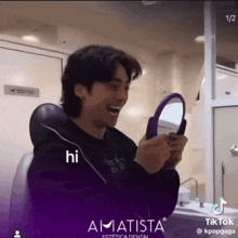a man is laughing while looking at himself in a mirror and the caption says hi