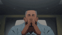 a man in a blue shirt has his eyes closed and his hands folded