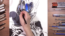 a person drawing a robot with a pencil on a piece of paper