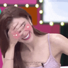 a woman in a purple bra is covering her face with her hand .