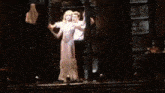 a man and woman are dancing in a room with a lot of books on the shelves .