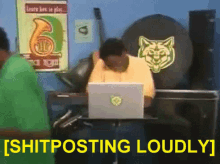 a man sitting at a desk with a laptop and the words shitposting loudly behind him
