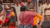 a man and woman are dancing in front of a crowd of people .