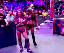 a couple of women standing next to each other on a stage .