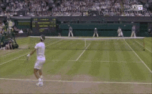 a man in a white shirt is standing on a tennis court