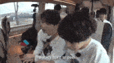 two young boys are sitting in the back seat of a car and one of them is saying but it 's hard to peel