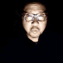 a man with glasses and a mustache is smiling