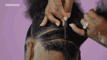 a woman combs her hair with a purple background and the website cosmopolitan.com is visible