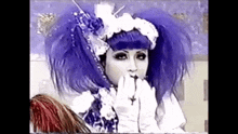 a woman with purple hair and white gloves is wearing a costume .