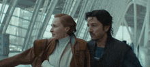 a man and a woman are standing next to each other in an airport