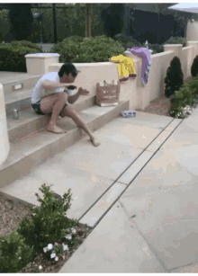 a man sits on a set of stairs looking at a phone