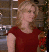 a blonde woman in a red dress is looking at something