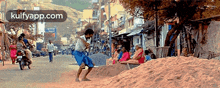 a man is kicking a pile of sand on the side of the road