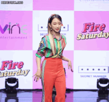 a woman stands in front of a sign that says fire saturday on it