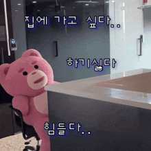 a pink teddy bear is sitting in a chair in front of a counter in a kitchen