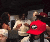 a man wearing a red hat with a large g on it