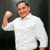 a man in a white shirt is flexing his arm