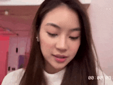 a close up of a woman 's face with a clock in the background .