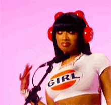 a woman is wearing headphones and a crop top while standing in front of a microphone .