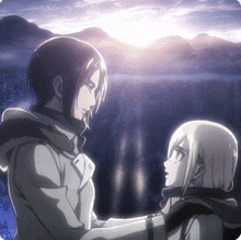 a man and a woman are looking at each other in front of a lake