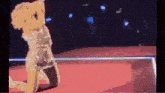 a woman is kneeling down on a red carpet in front of a stage .