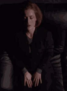 a close up of a woman 's face in a dark room with her eyes closed .