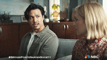 a man and a woman are sitting on a couch with a nbc logo behind them