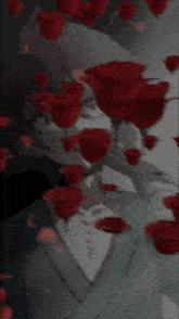a man is surrounded by red roses and petals falling from the sky