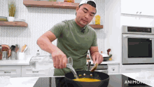 a man in a green shirt is pouring liquid into a frying pan with the words made in animatica at the bottom