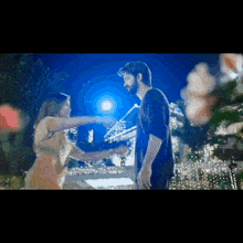 a man and a woman are dancing together in front of a full moon