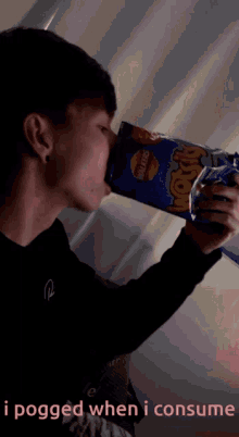 a young man drinks from a bag of lays chips