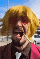 a man wearing a yellow wig and sunglasses is smoking a cigarette .
