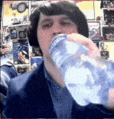 a man in a suit is drinking a bottle of water .