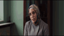 a woman wearing a hijab and a gray coat