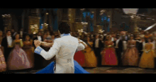 a man and woman dance in front of a crowd of people