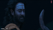 a man with a beard has a blue and white stripe on his forehead and the words pranay_varma on the bottom