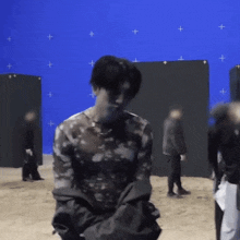 a group of people are standing in front of a blue screen .
